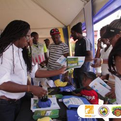 Bridgette Barrett, Community animator for the Adaptation Programme and Financing Mechanism (AP&FM) tells visitors to the booth about the project activities to help residents of the Bullhead and surrounding communities adapt to climate change. climate change